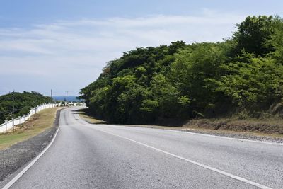 Road amidst trees against sky