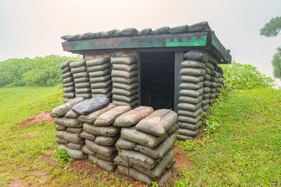 Stack of stones on field against clear sky