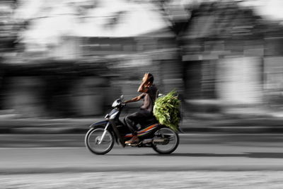 Man riding bicycle on road in city