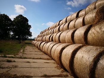 Close-up of stack of firewood in row against sky