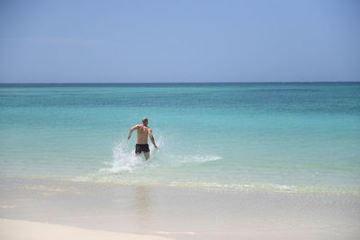 Man surfing in sea against sky