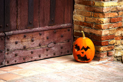 Jack o lantern outside old wooden door during halloween