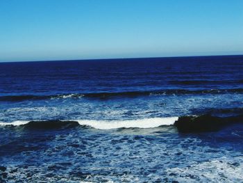 Scenic view of sea against clear blue sky