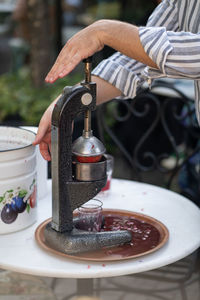 Process of squeezing pomegranate juice using manual mechanical juicer to obtain useful vitamins