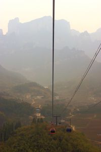 Overhead cable car on mountains against sky