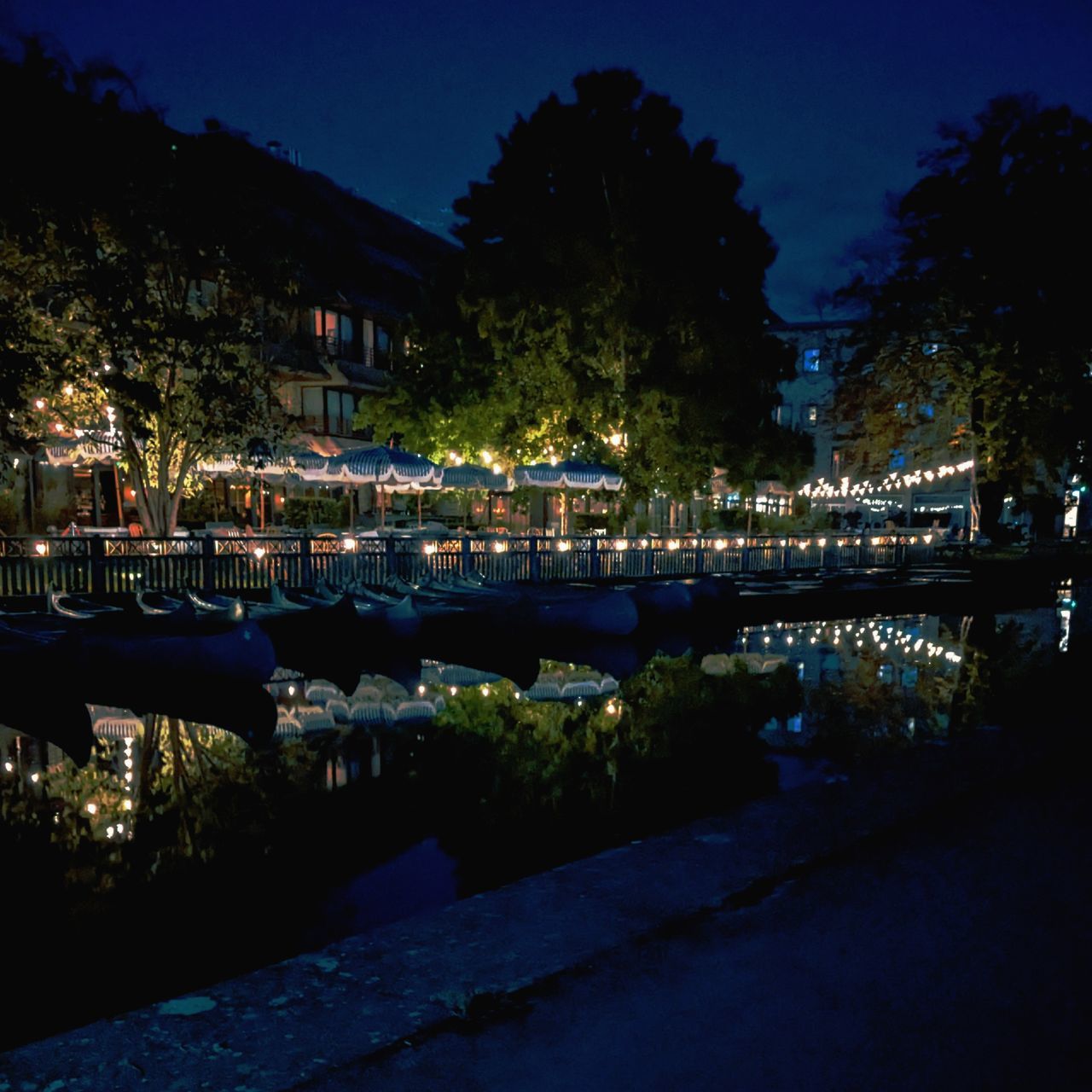 night, reflection, evening, dusk, water, tree, architecture, illuminated, plant, nature, city, built structure, building exterior, sky, cityscape, light, no people, travel destinations, lake, building, nautical vessel, transportation, outdoors, darkness, travel, blue, tourism