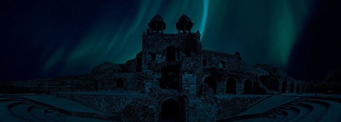 Low angle view of illuminated building against sky at night