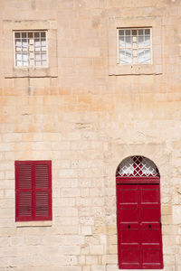 Low angle view of red window on wall of building