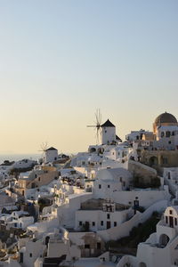 Buildings in town against clear sky during sunset