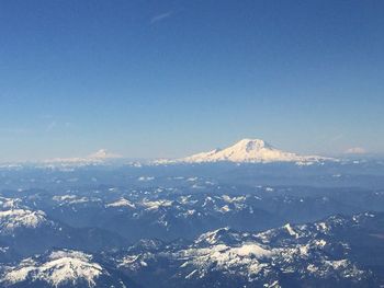 Aerial view of snowcapped mountains against clear blue sky