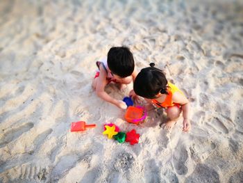 High angle view of children playing on sand at beach