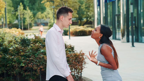 Side view of couple standing outdoors