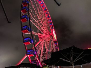 Low angle view of illuminated ferris wheel against sky