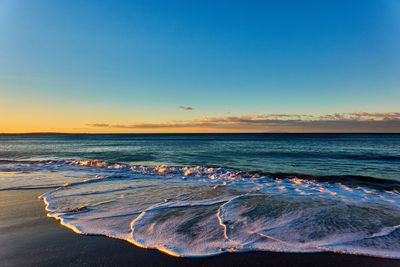 Scenic view of beach against sky during sunset