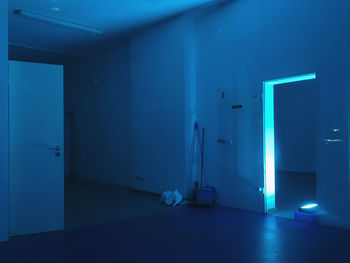 Neon blue illuminated building interior, empty room at night