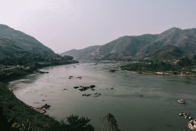 Scenic view of river and mountains against sky