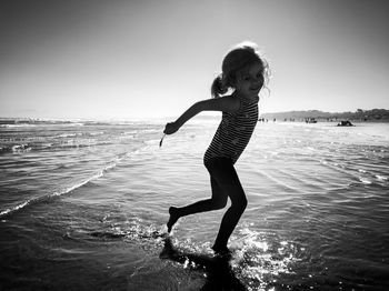 Full length of girl on beach against sky