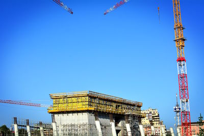 Low angle view of crane against sky