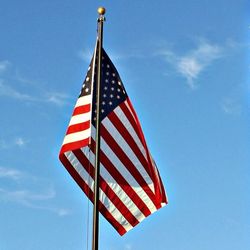 Low angle view of american flag against blue sky