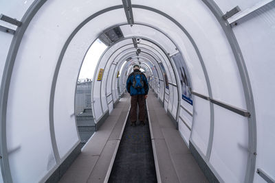 Rear view of man walking on footpath