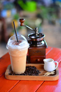 Close-up of coffee by grinder on table