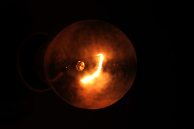 Close-up of illuminated lamp against black background