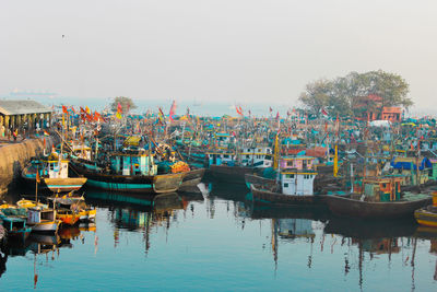 Boats moored in harbor against clear sky