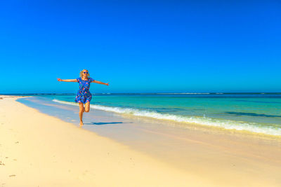 Full length of woman on shore at beach during sunny day