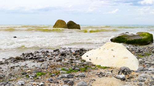 Rocks on beach against sky