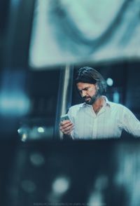 Reflection of man looking through window