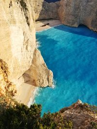 Rock formation against sea in sunny day