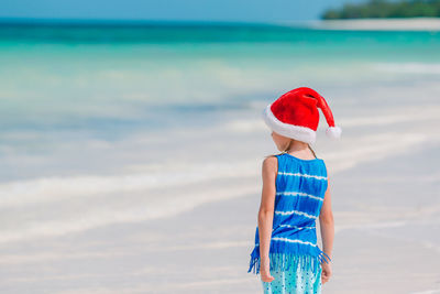 Boy standing on beach against sea