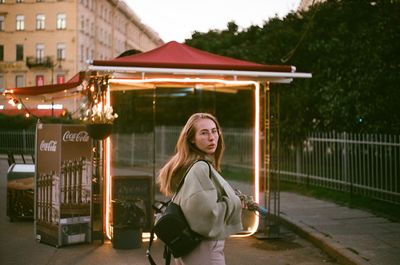 Portrait of smiling woman standing against building