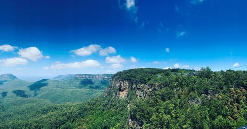 Panoramic view of landscape against blue sky