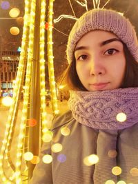 Portrait of woman in illuminated city at night