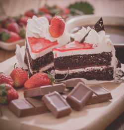 Close-up of cakes with chocolates and strawberries on table