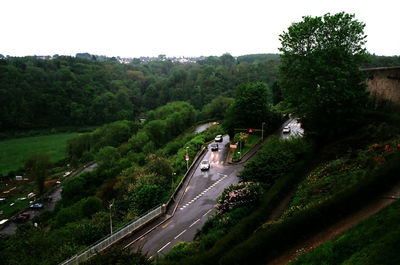 High angle view of road amidst trees against clear sky