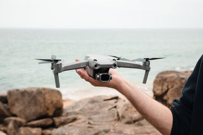 Cropped image of man holding drone