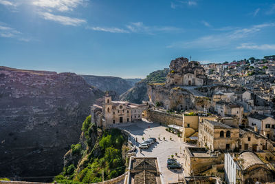 Houses on mountain at sassi di matera against blue sky