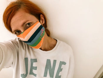 Close-up portrait of young man against white wall