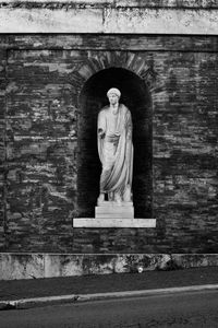 Statue against stone wall