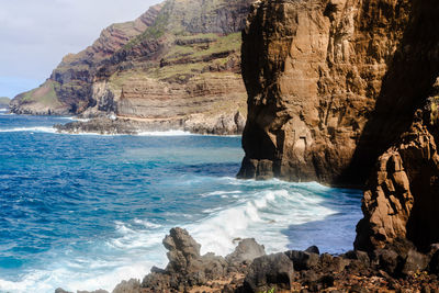 Scenic view of rocks on beach against sky