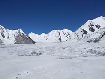 Scenic view of snowcapped mountains against clear blue sky