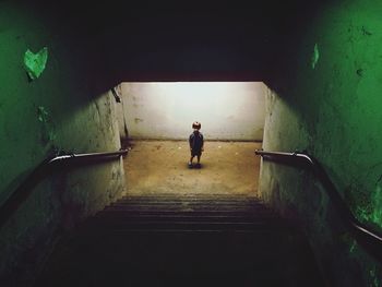 Portrait of cute boy standing in illuminated underground walkway