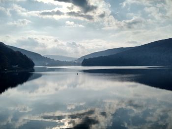 Scenic view of lake by mountains against sky