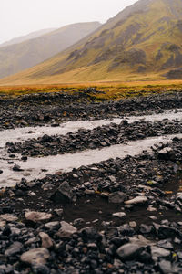 Surface level of pebble land against sky