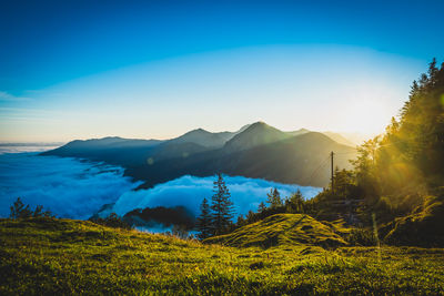 Scenic view of land and mountains against clear blue sky