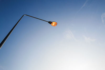 Low angle view of illuminated street light against sky