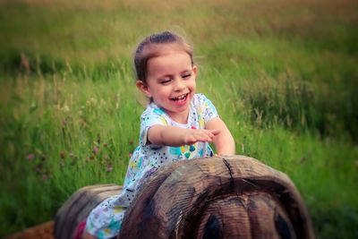 Girl sitting on wood at land