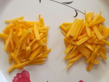 Close-up of fries and yellow chili peppers on plate